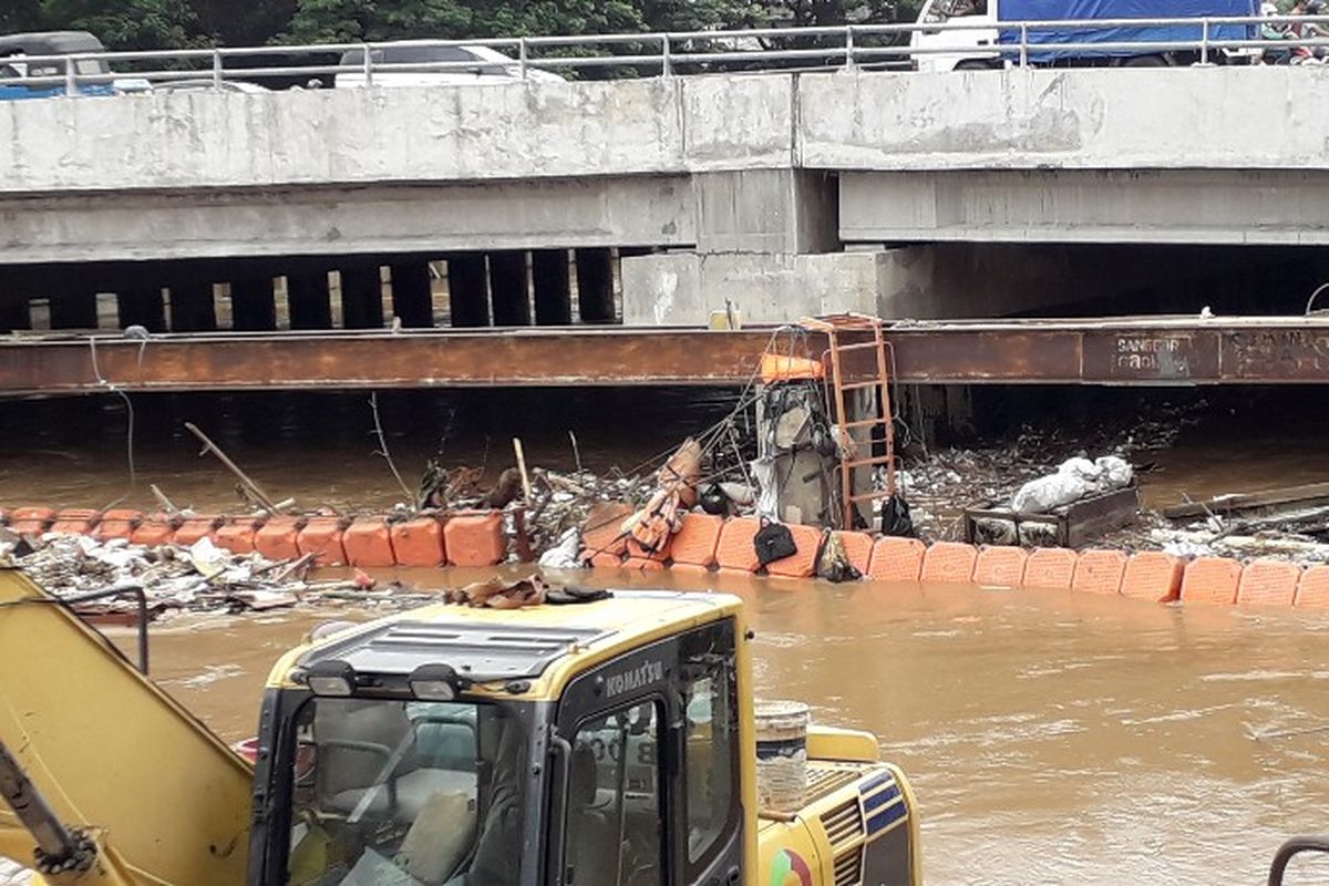 Sampah menumpuk dan tersangkut akibat banjir kiriman dari Bogor di sekatan kali Banjir Kanal Barat, Jembatan Besi, Jakarta Barat pada Rabu (7/2/2018). 