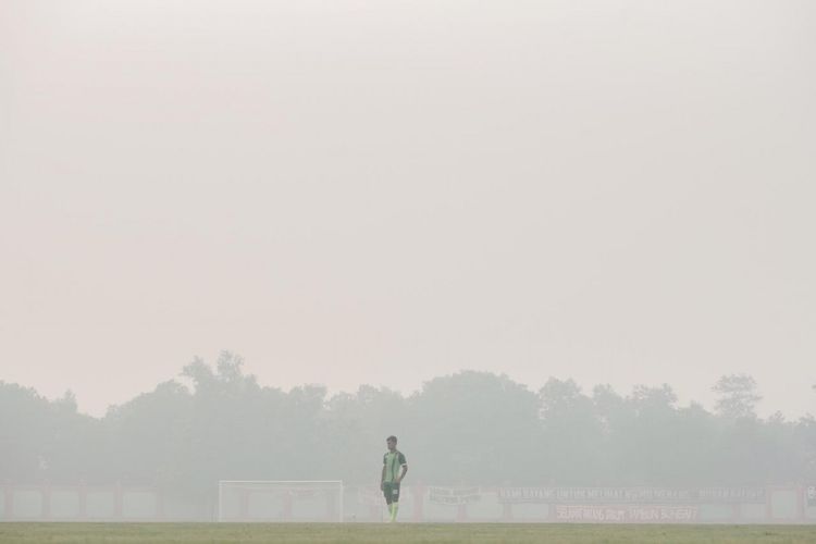 Osvaldo Haay berdiri di Stadion Tuah Pahoe yang diselimuti oleh kabut asap, Suasana kabut asap pekat ini dirasakan skuad Bajol Ijo saat menjalani sesi match official training pagi tadi. (Persebaya)