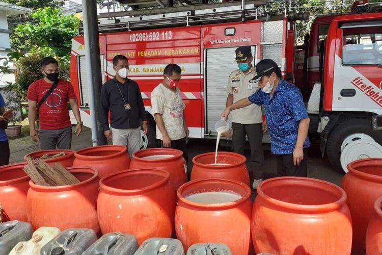 Bupati Banjarnegara, Budhi Sarwono mengecek barang bukti berupa tuak yang disita anggota Satpol PP dari sebuah rumah di Parakancanggah, Banjarnegara, Jawa Tengah, Rabu (23/12/2010).