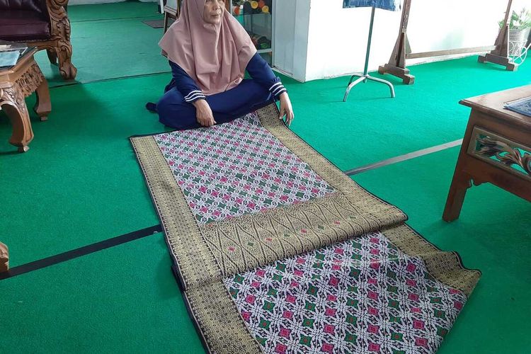 Budiana (51), satu di antara penenun kain songket Sambas, membentangkan satu di antara kain songket terbaiknya.