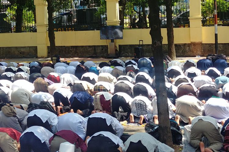 Massa pendukung Hizbut Tahrir Indonesia menunaikan salat zuhur berjemaah di depan gedung Pengadilan Tata Usaha Negara, Jakarta, Senin (7/5/2018) siang.