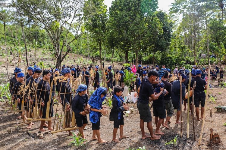 Petani baduy memainkan angklung sebelum proses penanaman padi huma di Desa Kanekes, Kecamatan Leuwidamar, Kabupaten Lebak, Banten, Kamis (26/10/2017). Masyarakat petani baduy memasuki musim bercocok tanam padi huma sesuai dengan kalender adat dan panen diperkirakan enam bulan ke depan dengan membuka ladang di kawasan hutan milik adat maupun menyewa lahan orang lain. KOMPAS.com/GARRY ANDREW LOTULUNG