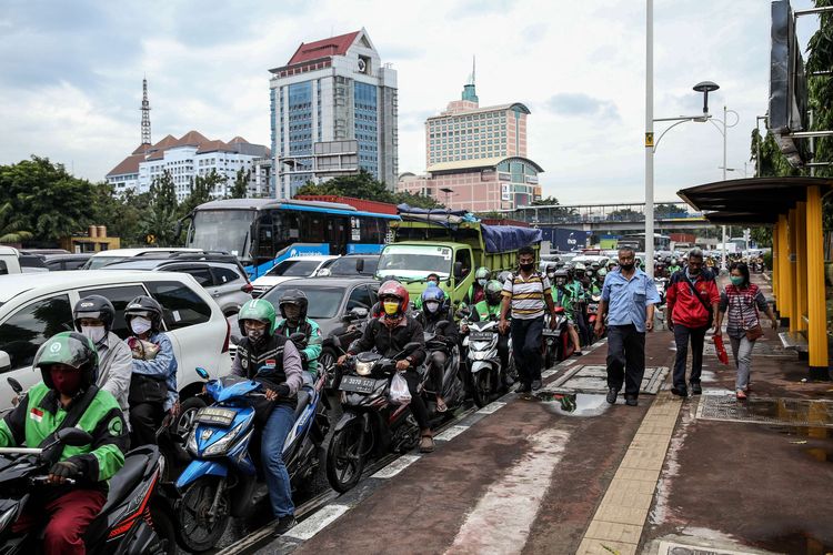Warga menggunakan masker saat mengendarai sepeda motor di Jl. Letjen S. Parman, Jakarta Barat, Senin (4/5/2020). Provinsi DKI Jakarta memasuki pelaksanaan pembatasan sosial berskala besar (PSBB) yang diperpanjang ke tahap kedua. Tujuan PSBB ini adalah untuk menekan penyebaran virus corona (Covid-19).