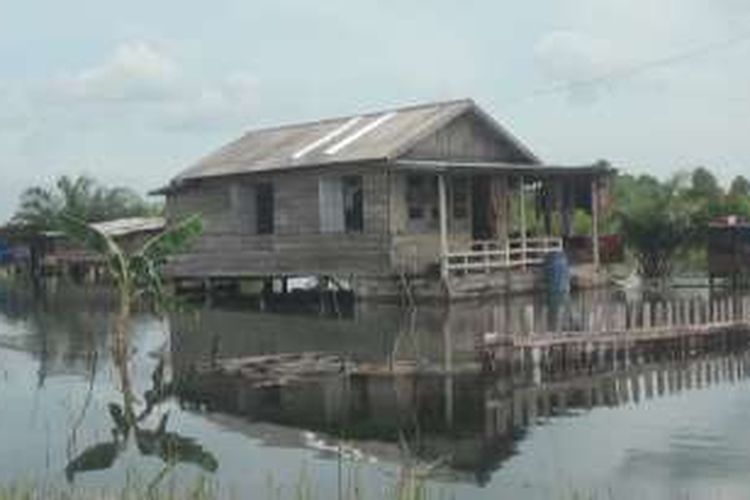 Salah satu rumah warga yang terendam banjir hingga pagarnya tinggal terlihat ujungnya saja, Banjir di Ogan Ilir belum ada tanda-tanda bakal surut, di sejumlah titik malah banjir semakin meluas