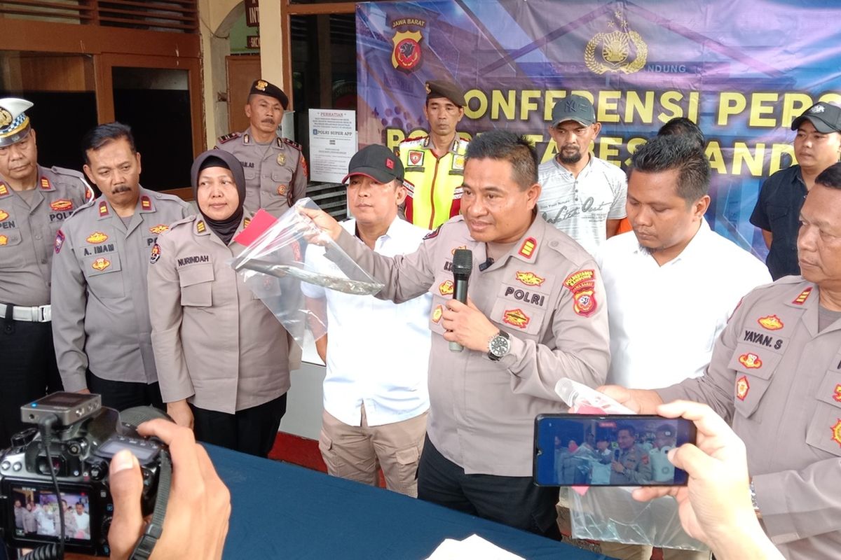 Polisi tengah memperlihatkan seorang preman yang telah melakukan pemerasan dan pengancaman terhadap bengkel bubut di Kota Bandung. Pelaku ditembak di kaki kirinya lantaran melakukan perlawanan saat ditangkap.