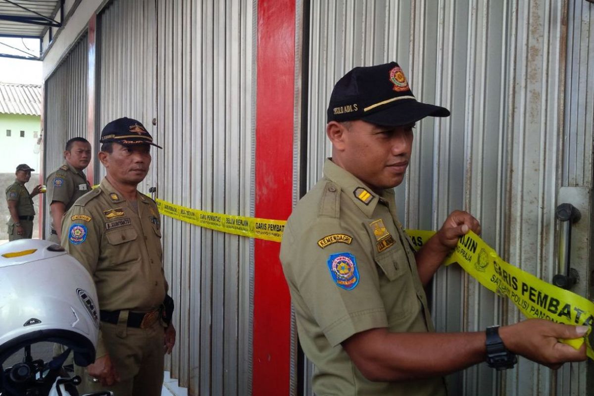 Petugas Satpol PP menyegel swalayan Alfamart di Jl Hasan Munadi No 9 RT 5 RW 7 desa Nyatnyono,   Kecamatan Ungaran Barat, Kabupaten Semarang, Rabu (19/7/2019) siang.