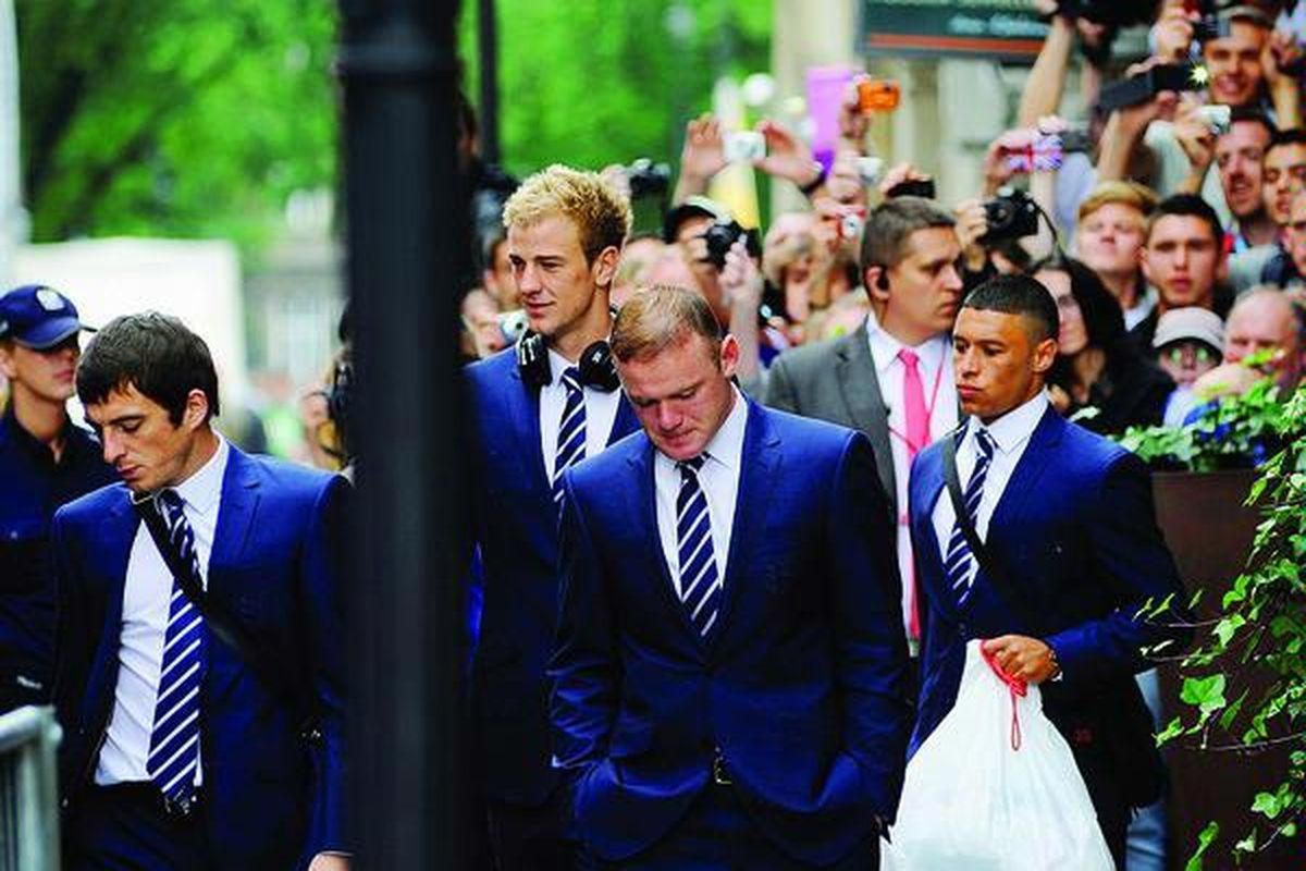 Pemain sepak bola tim nasional Inggris, Joe Hart (kedua dari kiri) dan Wayne Rooney (tengah), meninggalkan Hotel Stary, Senin (25/6), di Krakow, sehari setelah kekalahan  Inggris dari Italia di perempat final Piala Eropa 2012.