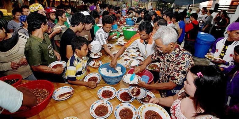 Masyarakat makan malam bersama sajian daging kerbau hasil kurban dalam prosesi adat Nalitn Taotn di Taman Budaya Sendawar, Kutai Barat, Kalimantan Timur, Kamis (7/11/2013). Prosesi adat ini tidak saja melibatkan etnis Tunjung dan Benuaq namun empat etnis lain Bahau Aoheng, Kenyah dan Melayu turut andil meramaikan acara tersebut.