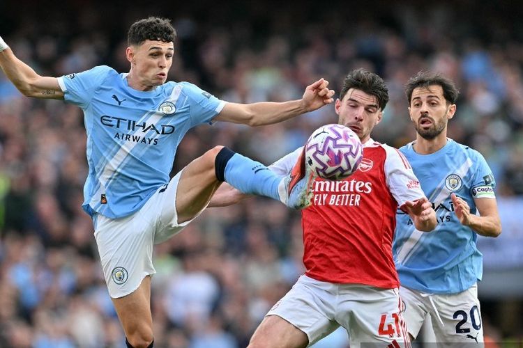 Phil Foden (kiri) berebut bola dengan Declan Rice (kanan) dalam pertandingan sepak bola Liga Inggris antara Arsenal vs Manchester City di Stadion Emirates di London pada 21 September 2025. (Foto oleh Glyn KIRK / AFP) / 