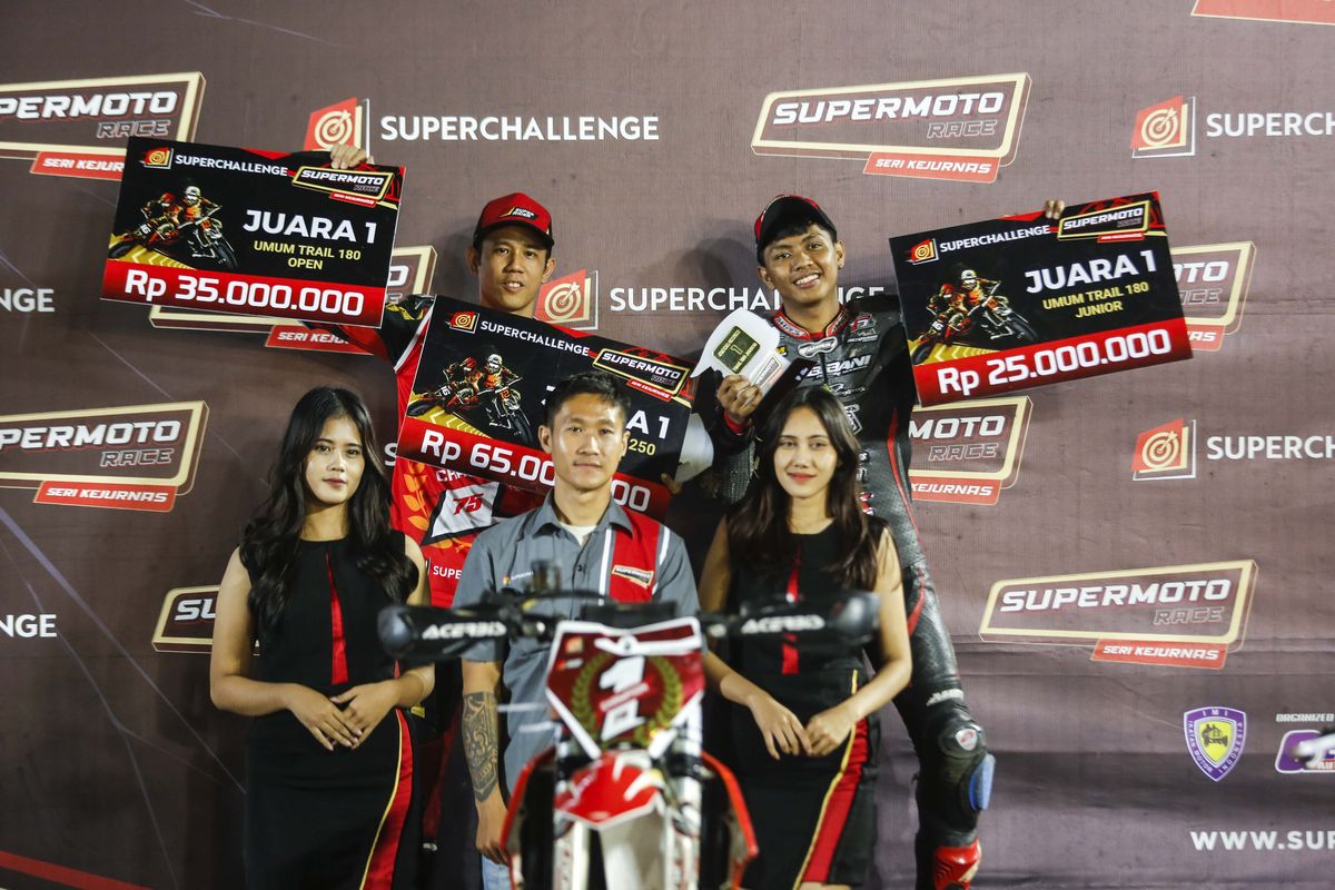 PUTARAN FINAL
Pebalap Superchallange Supermoto Tommy Salim (kiri), saat menerima hadiah di podiun setelah berwhasil menjadi juara umum kelas FFA 250 di sirkuit Boyolali, Sabtu (31/8).