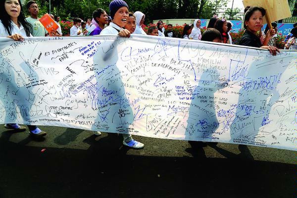 Kain panjang digelar oleh ICW dan LBH Jakarta untuk mengajak masyarakat menuliskan komitmen mereka untuk tidak terlibat politik uang dalam Pilkada DKI Jakarta putaran kedua, di Bundaran Hotel Indonesia, Jakarta, Minggu (16/9).