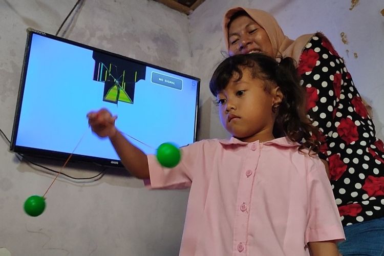 Lisa Aisyah (30) bersama anaknya Asila Septiani (5) menunjukan televisi yang rusak terkena lato-lato yang terlempar dari tangan Asila, Minggu (8/1/2023).