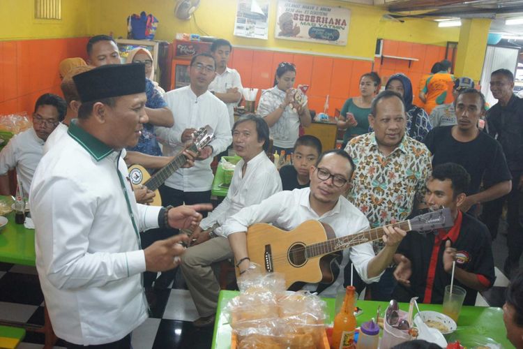 Menteri Tenaga Kerja dan Transmigrasi Hanif Dhakiri saat memetik gitar dan bernyanyi di sela menyantap bakso Yamin di Jalan Niaga, Karawang, Sabtu (21/4/2018).