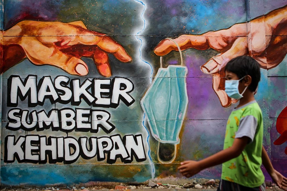 Seorang bocah melintas di depan mural tentang penggunaan masker di Kota Tangerang, Banten, Minggu (21/12/2020). Mural tersebut dibuat sebagai edukasi kepada masyarakat untuk selalu menggunakan masker guna mencegah penyebaran COVID-19. ANTARA FOTO/Fauzan/aww.