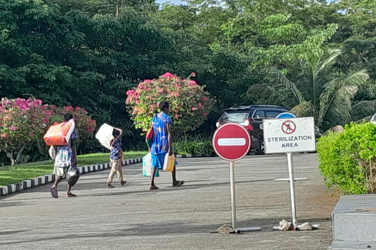 Dua orang warga Papua Nugini beserta seorang anak tampak membawa barang-barang yang dibeli di Pasar Wisata PLBN Skouw, dan hendak kembali ke Kampung Wutung, Vanimo, Papua Nugini, Selasa (15/8/2023).