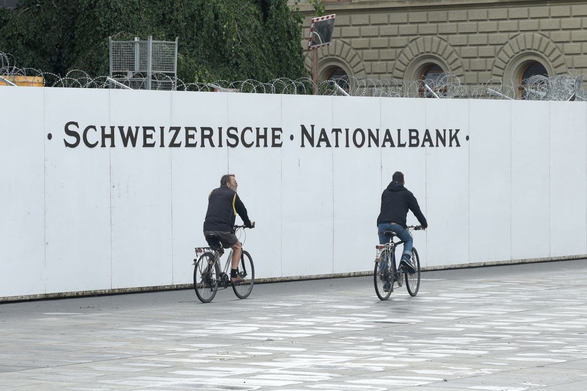 Dua pesepeda tampak melintasi area Bank Sentral Swiss (SNB) di Bern, Swiss. Gambar diambil pada 4 Juni 2017.