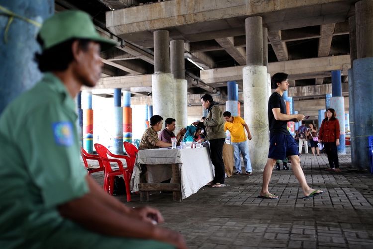 Suasana saat warga melakukan pencoblosan di TPS 20 dan 21 di kolong jembatan kawasan Penjaringan, Jakarta, Rabu, (19/4/2017). Pasangan calon gubernur-wakil gubernur DKI Jakarta, Anies Baswedan- Sandiaga Uno berdasarkan hasil quick count dari berbagai lembaga survei unggul dibanding pasangan calon Basuki Tjahaja Purnama- Djarot Saiful Hidayat.