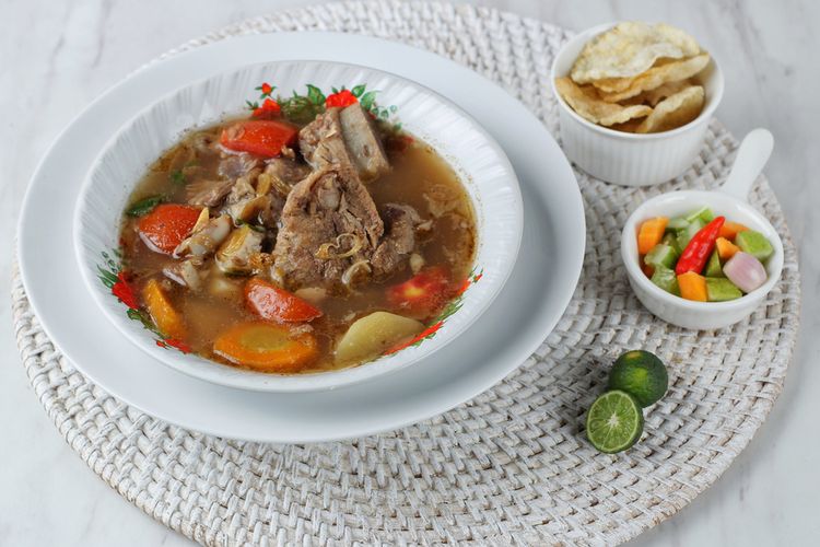 Ilustrasi sup iga yang disajikan dengan acar dan emping.  