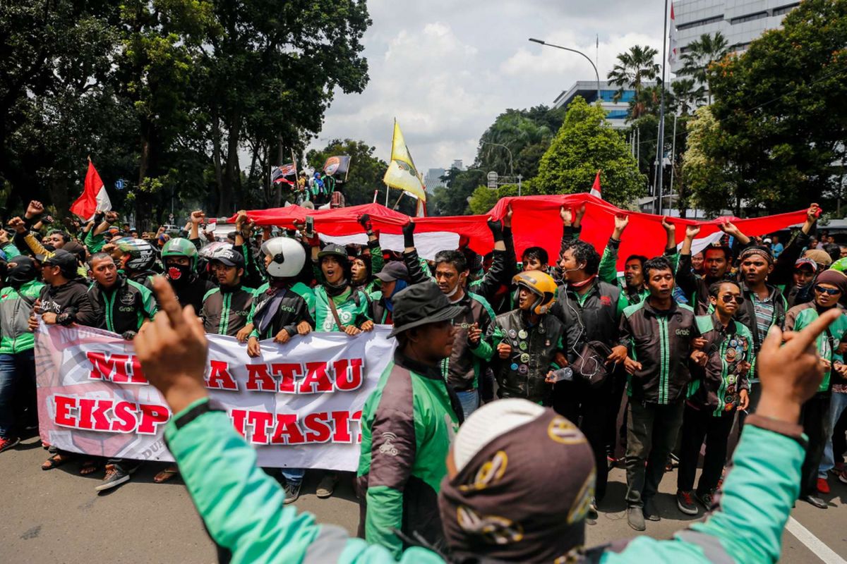 Pengemudi ojek online melakukan aksi unjuk rasa di depan Istana Negara, Jakarta Pusat, Selasa (27/3). Massa dari pengemudi ojek online menuntut pemerintah membantu untuk berdiskusi dengan perusahaan transportasi online agar merasionalkan tarif.