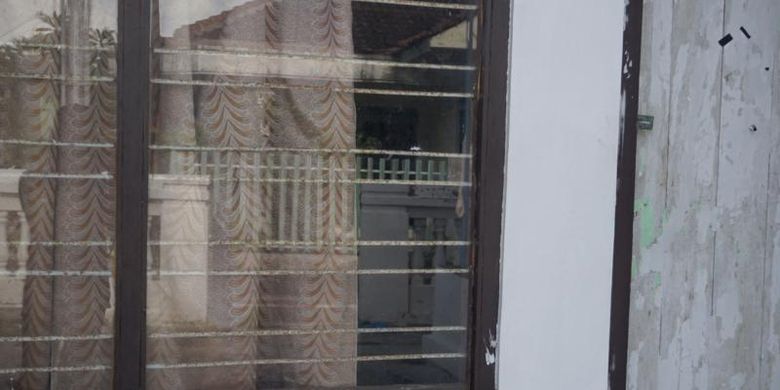 Jendela di samping pintu tempat tinggal Siti dan Daniel yang kini sudah kosong.