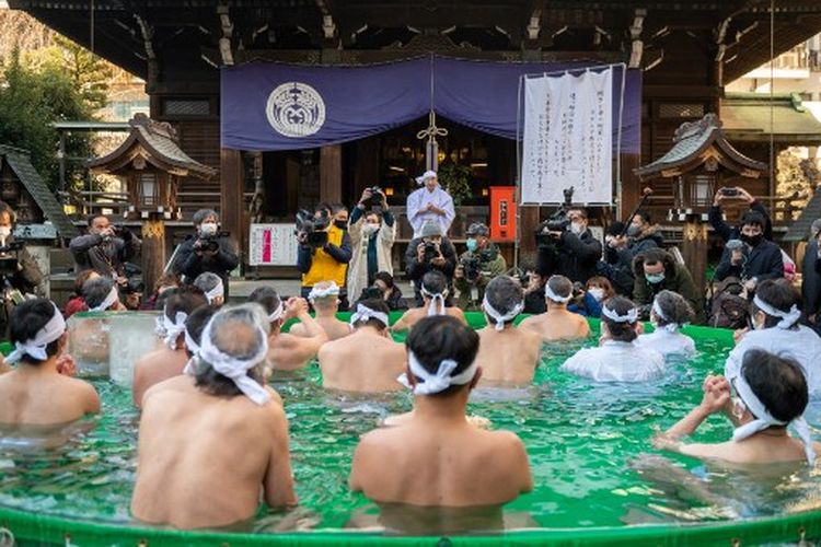 Umat Shinto di Kuil Teppou Zu Inari mandi dengan air dingin untuk menyucikan jiwa dan raga mereka selama ritual Tahun Baru di Tokyo pada 9 Januari 2022.