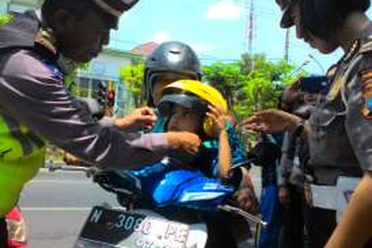 Seorang anak mendapatkan helm gratis dari Polisi dalam operasi simpatik di Kabupaten Probolinggo. 