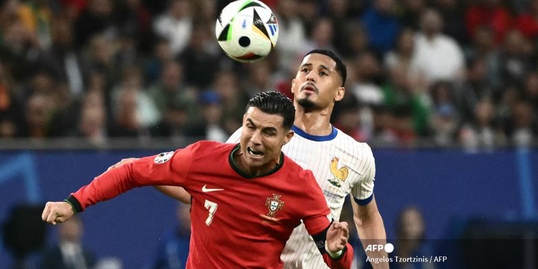 Cristiano Ronaldo melakukan duel udara dengan WIlliam Saliba dalam laga perempat final Euro 2024 antara Portugal vs Perancis di Volsparkstadion, Hamburg, Jerman, 5 Juli 2024. (Photo by Angelos Tzortzinis / AFP)