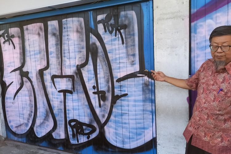 Willy Sudjono pemilik toko saat memperlihatkan corat-coret dan pelaku yang terekam CCTV, Rabu (18/9/2024)