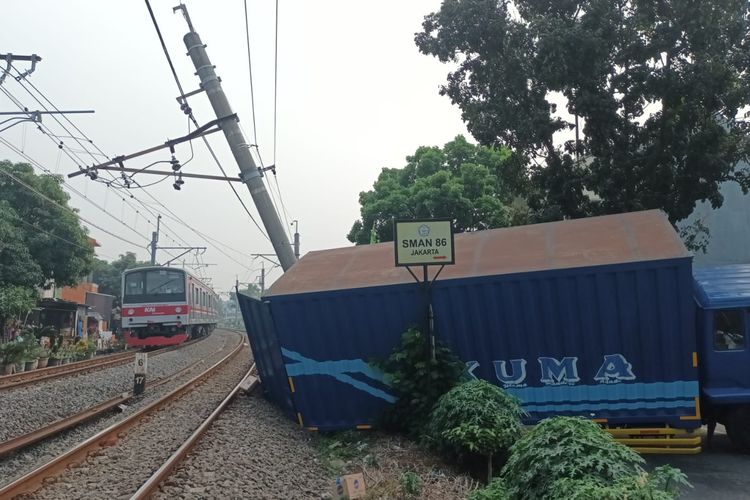Penampakan truk yang jeblos ke parit dan mengakibatkan tiang listrik aliran atas (LAA) miring di bilangan Pesanggrahan, Jakarta Selatan, Selasa (25/7/2023).