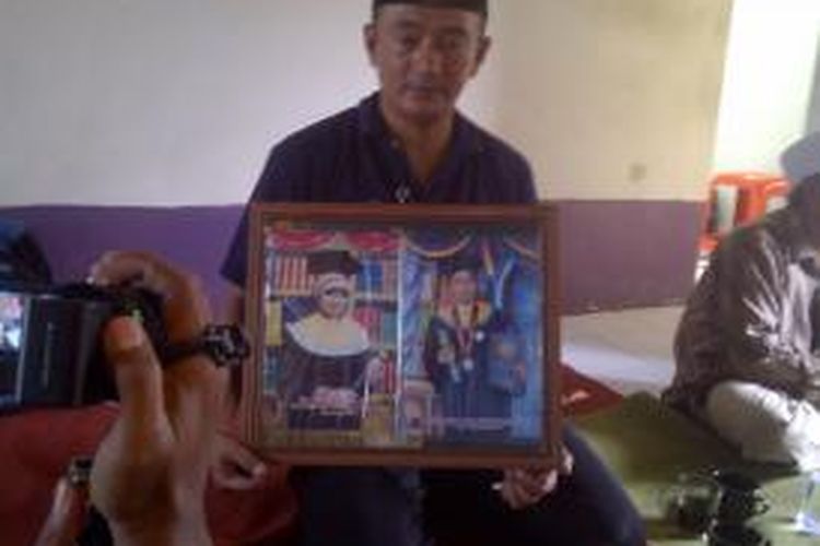 Nanang, paman Ayu memegang foto Ayu di rumah Ayu Diah, pegawai PT KAI pusat di Bandung, yang menjadi korban kecelakaan KA Malabar jurusan Bandung-Malang.Sabtu (5/4/2014).