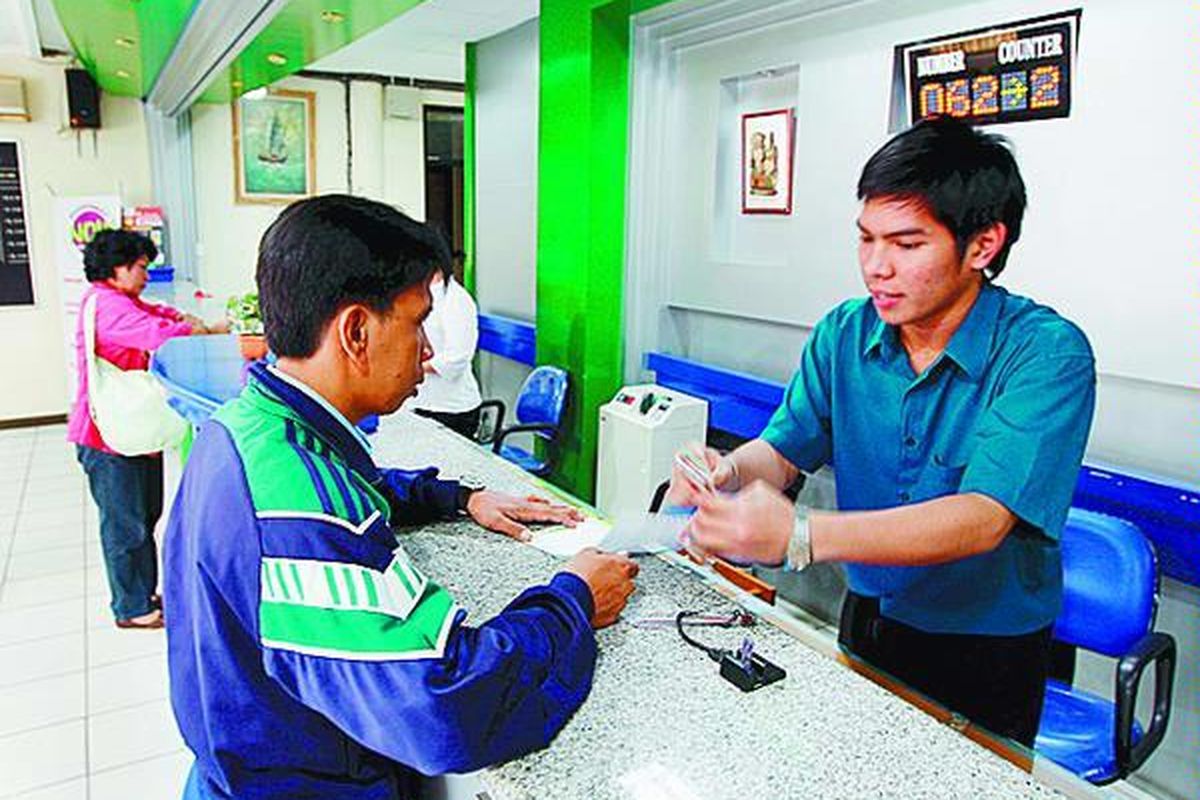Oji (kiri) menerima penjelasan dari petugas Pegadaian Kantor Cabang Pasar Senen, Jakarta Pusat, saat menggadaikan barang miliknya, Kamis (24/4).  
