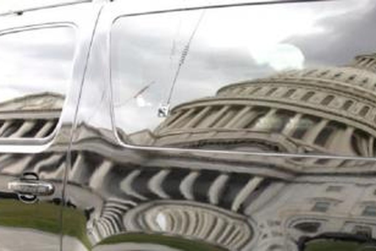 Bayangan gedung Capitol pada sebuah mobil yang diparkir di pelataran gedung di Washington, DC (28/9).