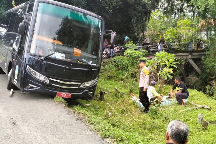 Kondisi bus yang terperosok saat pakai Google Maps di jalan kawasan pemakaman umum Dusun Talun, Desa Pelem, Kabupaten Kediri, Jawa Timur, Minggu (26/2/2023). 