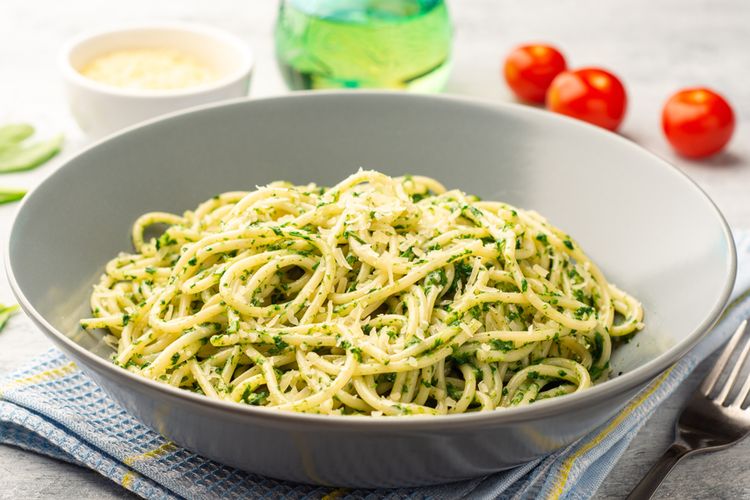Ilustrasi spaghetti dengan saus warna hijau. 