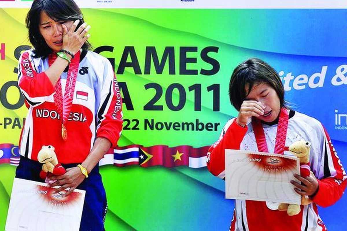 Pebalap sepeda Indonesia, Risa Suseanty (kiri) dan Fitriyanti Riyanti, menitikkan air mata saat lagu Indonesia Raya dikumandangkan pada upacara pengalungan medali cabang balap sepeda nomor downhill SEA Games XXVI/2011 di Gunung Pancar, Bogor, Sabtu (12/11). Risa meraih emas, sementara Fitri meraih perak. Medali perunggu diraih pebalap Thailand, Vipavee Deekabales.