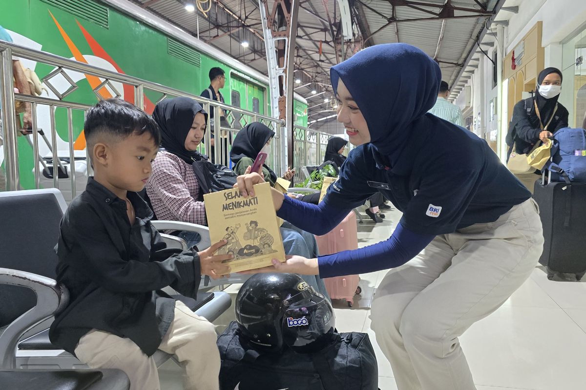 Petugas KAI terlihat membagikan paket takjil gratis kepada penumpang kereta api.
