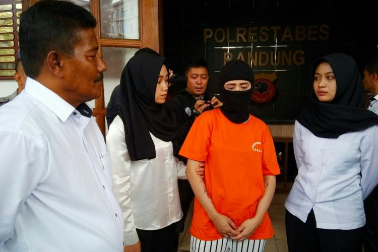 Imel (27) tengah di jaga polisi wanita di Mapolrestabes Bandung, Jalan Jawa, Kota Bandung, Senin (26/2/2018). Imel ditangkap lantaran menjual alat isap sabu atau bong secara online.