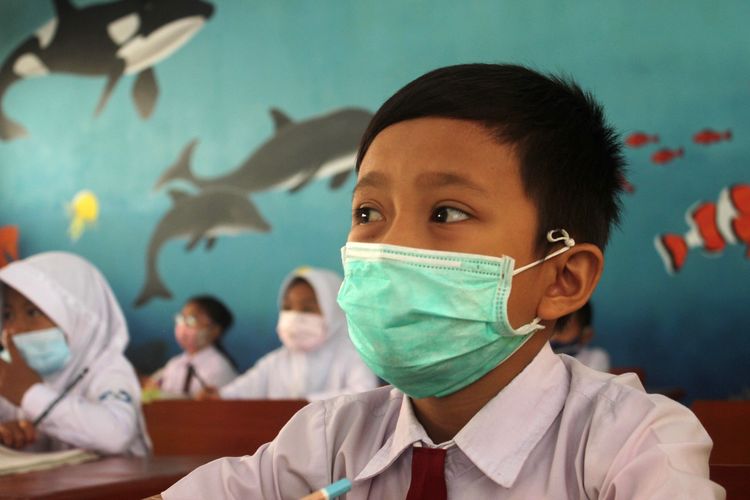 Sambil mengenakan masker, seorang murid sekolah dasar di Kabupaten Cianjur, Jawa Barat, sedang mengikuti kegiatan pembelajaran tatap muka di sekolah, Jumat (10/9/2021)