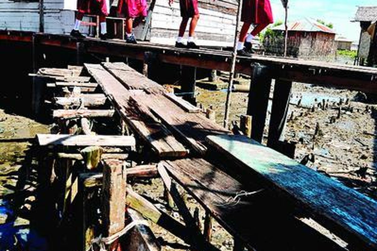 Para siswa Sekolah Dasar Negeri 068009 pulang ke rumah seusai sekolah di Kampung Nelayan, Kelurahan Belawan I, Kota Medan, Sumatera Utara, Senin (7/5). Di Kampung Nelayan, hanya 20 persen anak yang tetap bersekolah hingga lulus SD. Sisanya putus sekolah karena mengikuti orangtua mencari nafkah sebagai nelayan. 