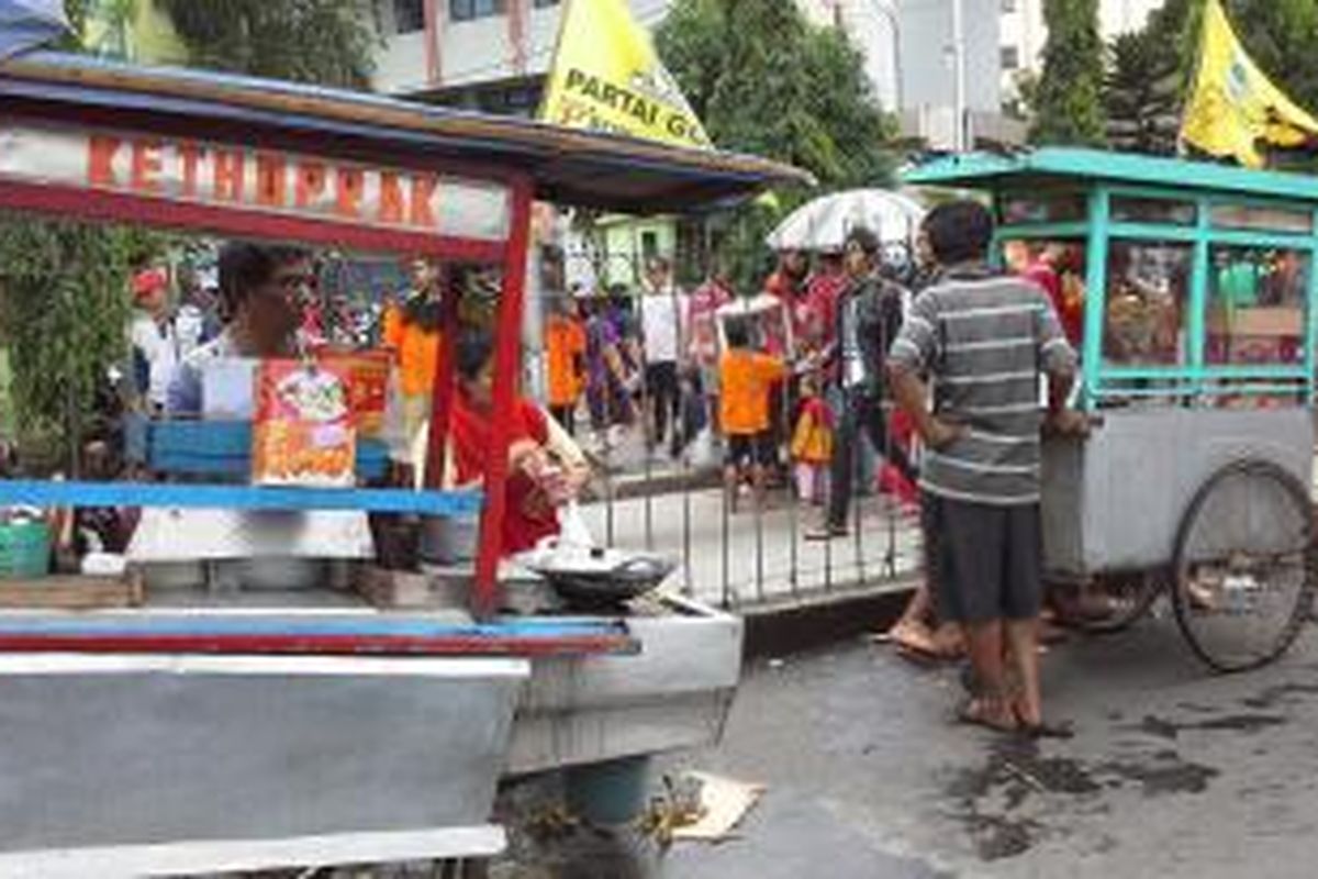 Pedagang ketoprak tengah menjajakan dagangan di lokasi banjir Kampung Pulo, Kampung Melayu, Jakarta Timur, Sabtu (18/1/2014).