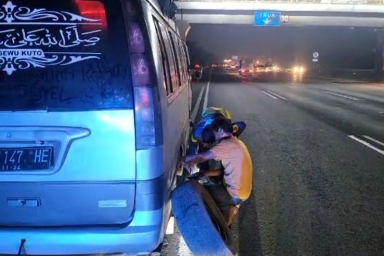 Polisi membantu warga yang kendaraannya mengalami pecah ban di Tol Jakarta - Cikampek, Selasa (18/4/2022) dini hari.