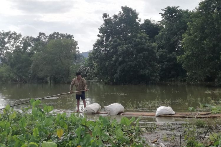 Korban banjir di Kabupaten Gowa, Sulawesi Selatan mulai beraktifitas menggunakan rakit bambu. Kamis, (24/1/2019).