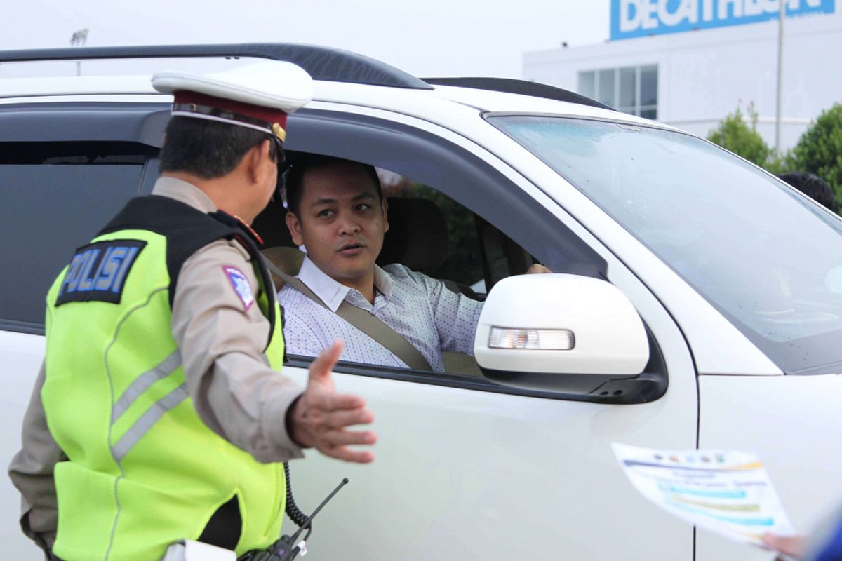 Petugas kepolisian mengarahkan kendaraan yang melintas saat uji coba sistem ganjil genap di Pintu Tol Kunciran 2, Tangerang, Banten, Senin (16/4/2018). Kepala Badan Pengelola Transportasi Jabodetabek (BPTJ) Bambang Prihartono menargetkan, kebijakan sistem ganjil-genap di tol Tangerang-Jakarta bisa mengurangi kepadatan menuju Jakarta hingga 50 persen.