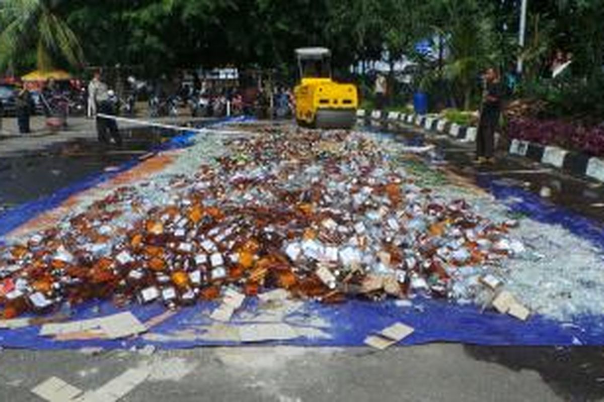 Belasan ribu botol minuman keras dimusnahkan dengan cara digilas dengan buldoser di depan halaman Mapolsek Pulogadung, Jakarta Timur. Jumat (28/2/2014).