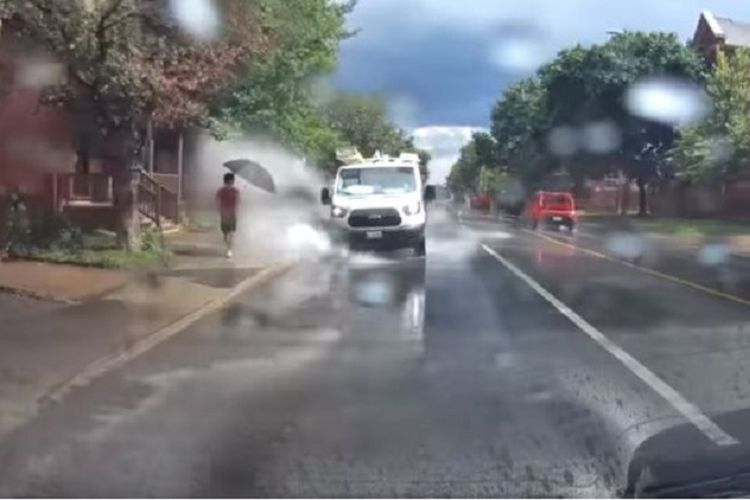 Dalam foto hasil tangkapan layar ini terlihat sebuah minibus milik perusahaan konstruksi di Ottawa, Kanada mencipratkan air di jalanan ke arah seorang pejalan kaki.