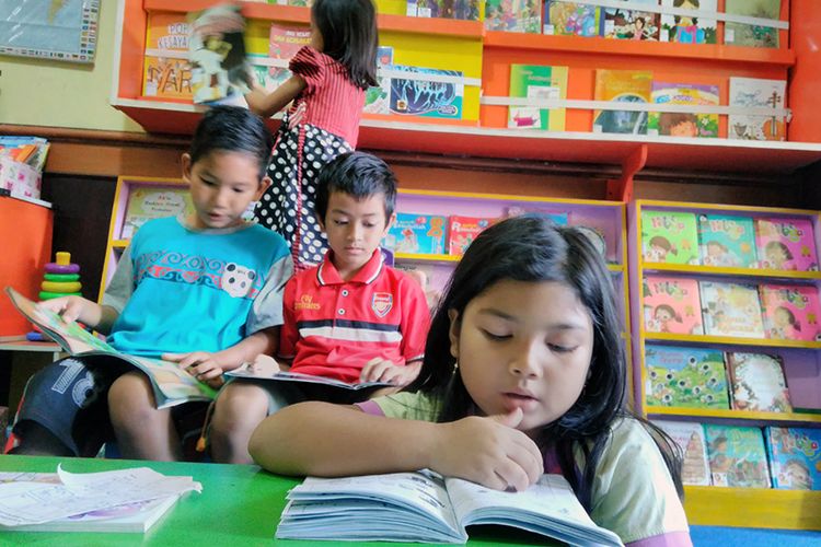 Anak-anak membaca di Taman Bacaan Masyarakat Rumah Pelangi di Desa Suci, Kecamatan Manyar, Gresik, Jawa Timur.