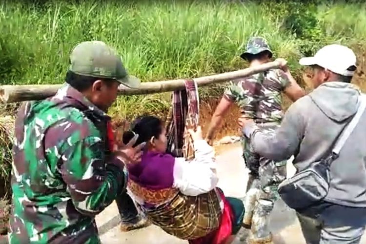 Dua anggota TNI dari Kodim 0608/Cianjur menandu seorang ibu yang baru melahirkan sejauh 2 kilometer di Desa Mekarmulya, Kecamatan Cikalongkulon, Cianjur karena kondisi jalan yang rusak.