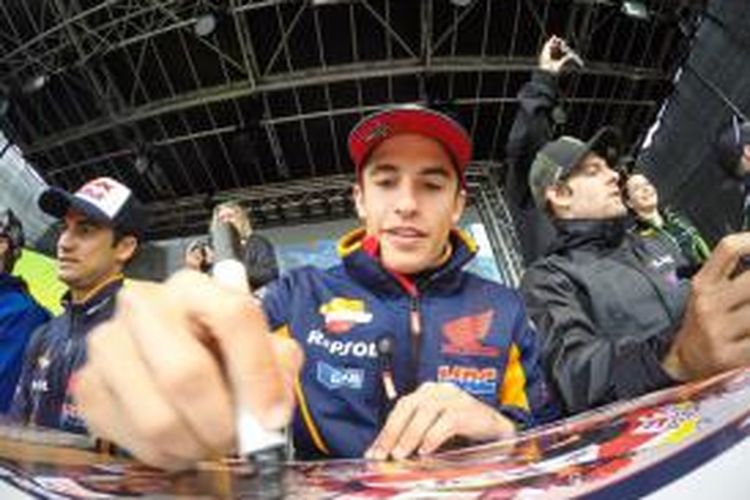 Pebalap Repsol Honda asal Spanyol, Marc Marquez (tengah), memberikan tanda tangan untuk para penggemar jelang GP Jerman di Sachsenring, Kamis (9/7/2015).