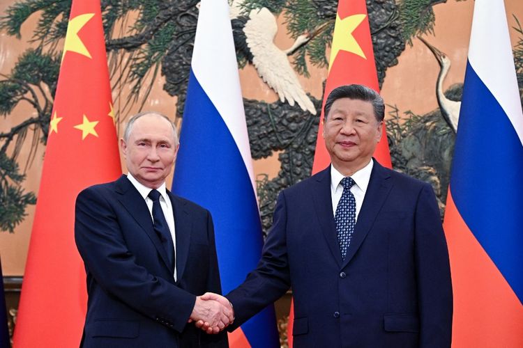 Dalam foto yang didistribusikan oleh badan pemerintah Rusia Sputnik ini, Presiden Rusia Vladimir Putin (kiri) berjabat tangan dengan Presiden China Xi Jinping selama pertemuan di Balai Agung Rakyat di Beijing pada 2 September 2025. Reuters menarik video CCTV yang menampilkan obrolan Xi Jinping dan Vladimir Putin yang bocor soal hidup abadi hingga 150 tahun, usai TV China memintanya dihapus.