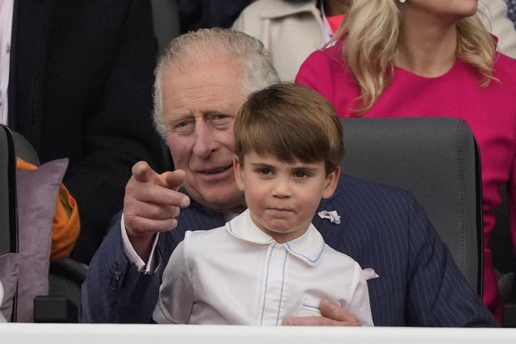 Pangeran Charles, Prince of Wales (kiri) memangku Pangeran Louis dalam acara Platinum Pageant di London 5 Juni 2022 dalam bagian perayaan platinum jubilee Ratu  Elizabeth II 